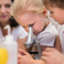 Two pupils looking into a microscope